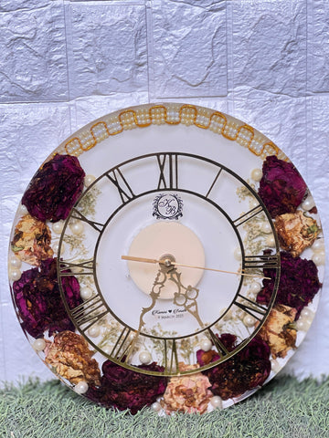 Resin 12 inch clock with In 3/4 part covered with flowers , upr part with pearl 2 lines white base in middle pink colour with logo in center Varmala Preservation Resin 12 inch clock with In 3/4 part covered with flowers , upr part with pearl 2 lines white base in middle pink colour with logo in center Varmala Preservation