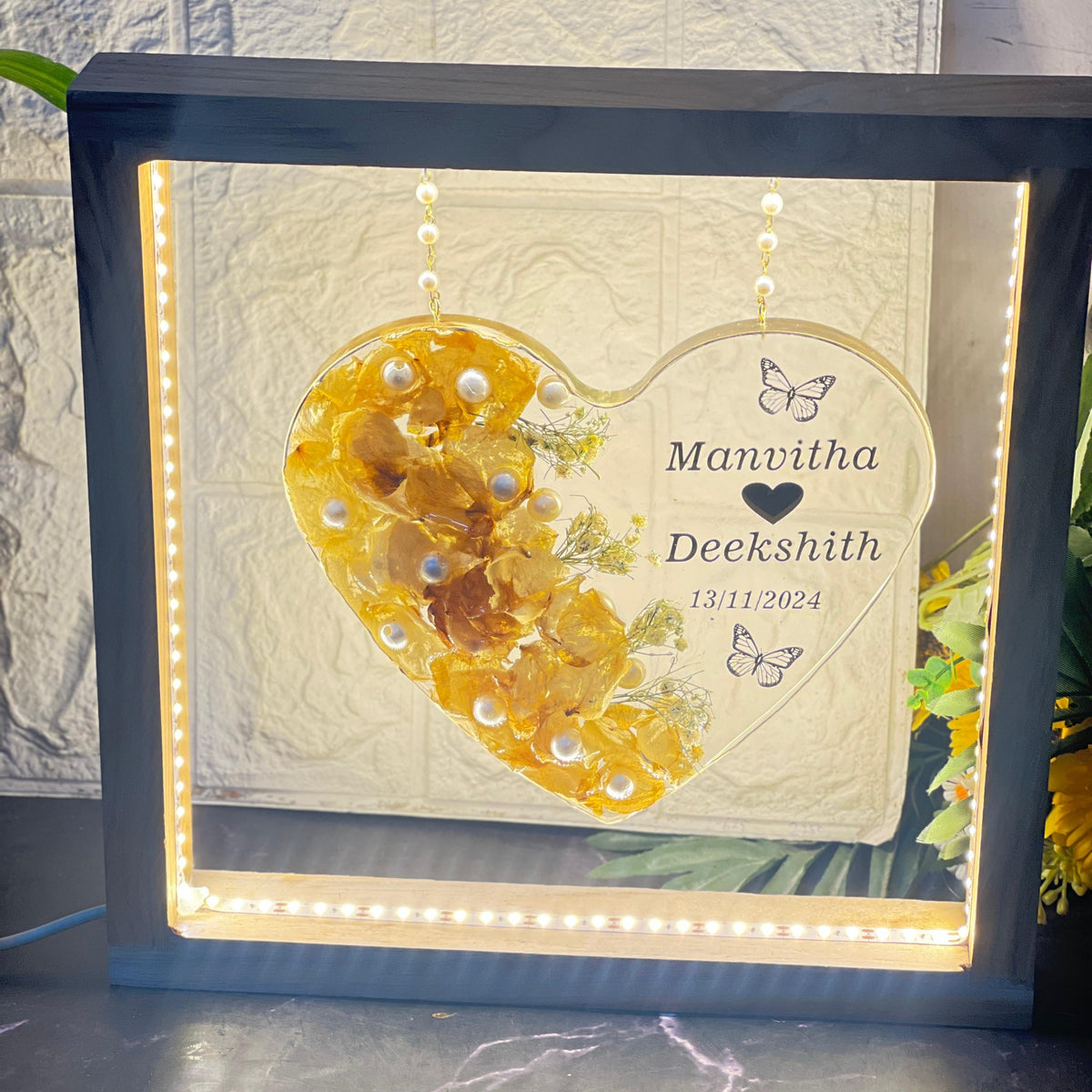 Hanging resin heart with golden flowers in a grey LED frame