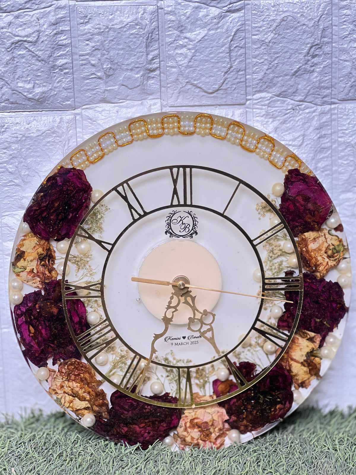 Resin 12 inch clock with In 3/4 part covered with flowers , upr part with pearl 2 lines white base in middle pink colour with logo in center Varmala Preservation
