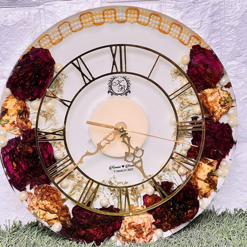 Resin 12 inch clock with In 3/4 part covered with flowers , upr part with pearl 2 lines white base in middle pink colour with logo in center Varmala Preservation