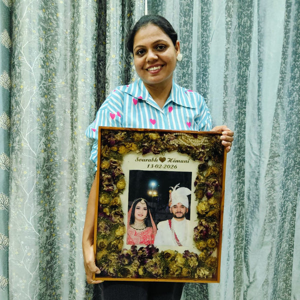 A dark teakwood varmala frame with the couple photo